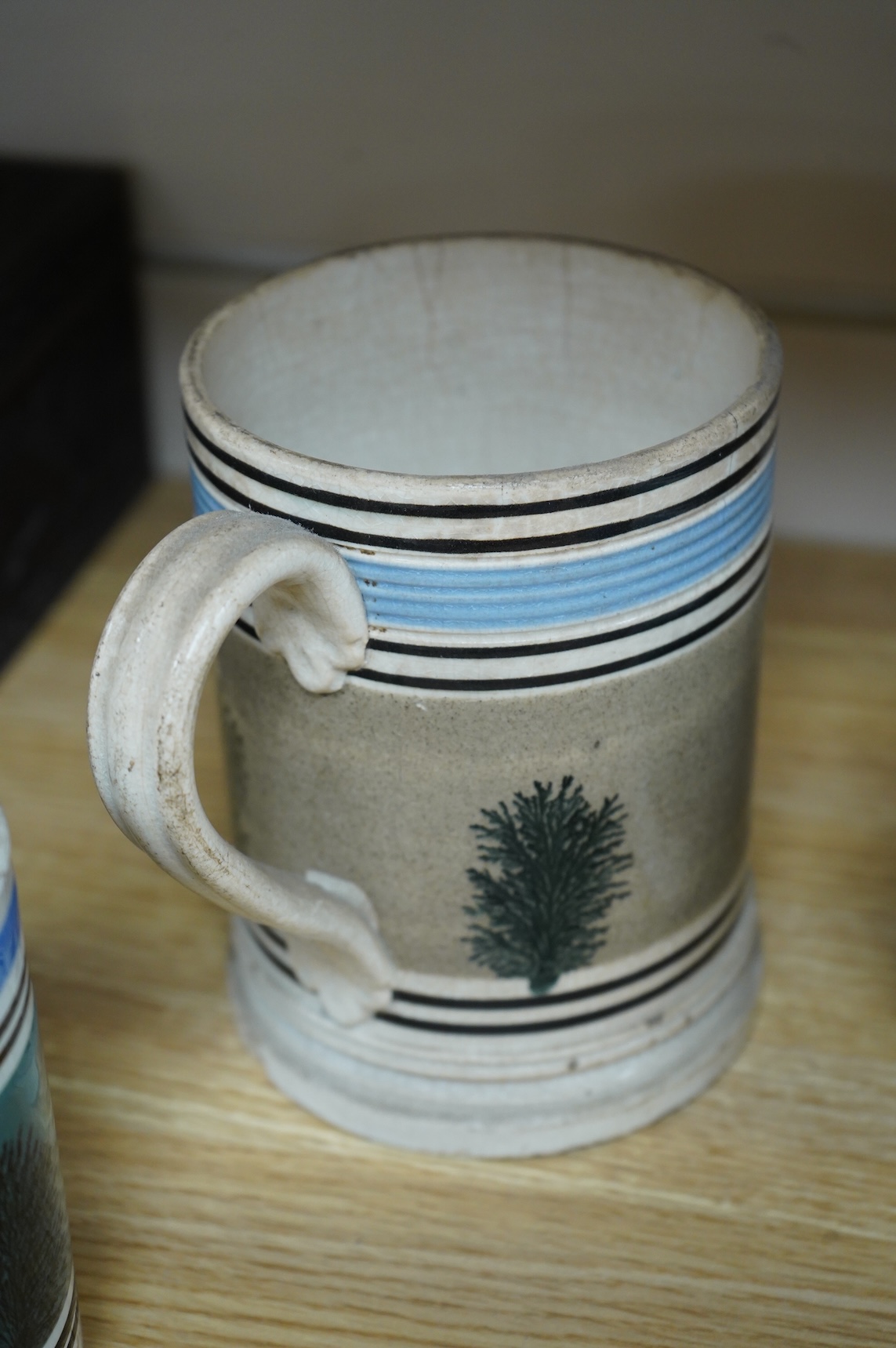 Two early 19th century Mocha ware jugs and two mugs, largest 16cm high